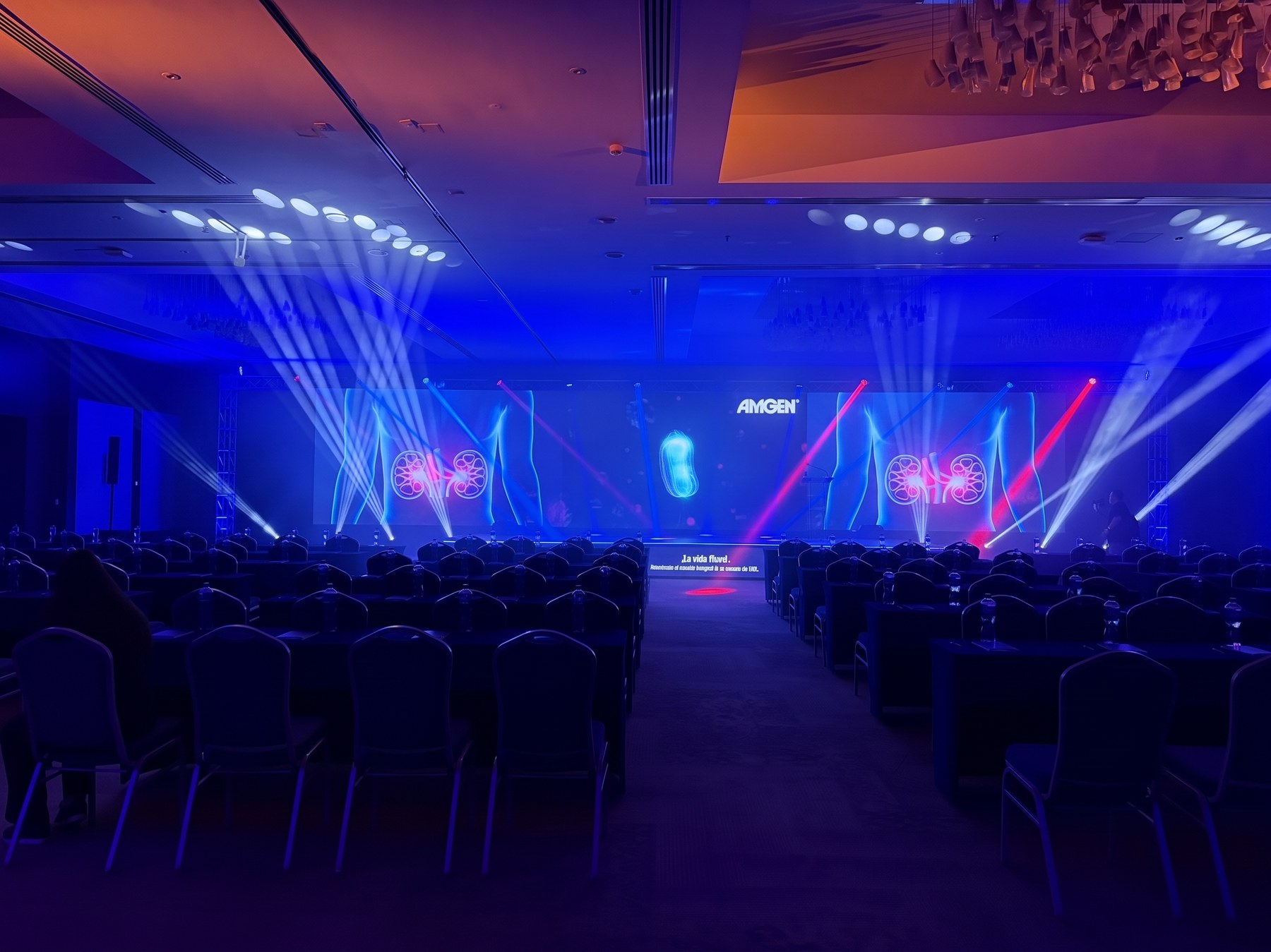 Salón de congreso con pantallas LED, iluminación escénica y montaje de butacas