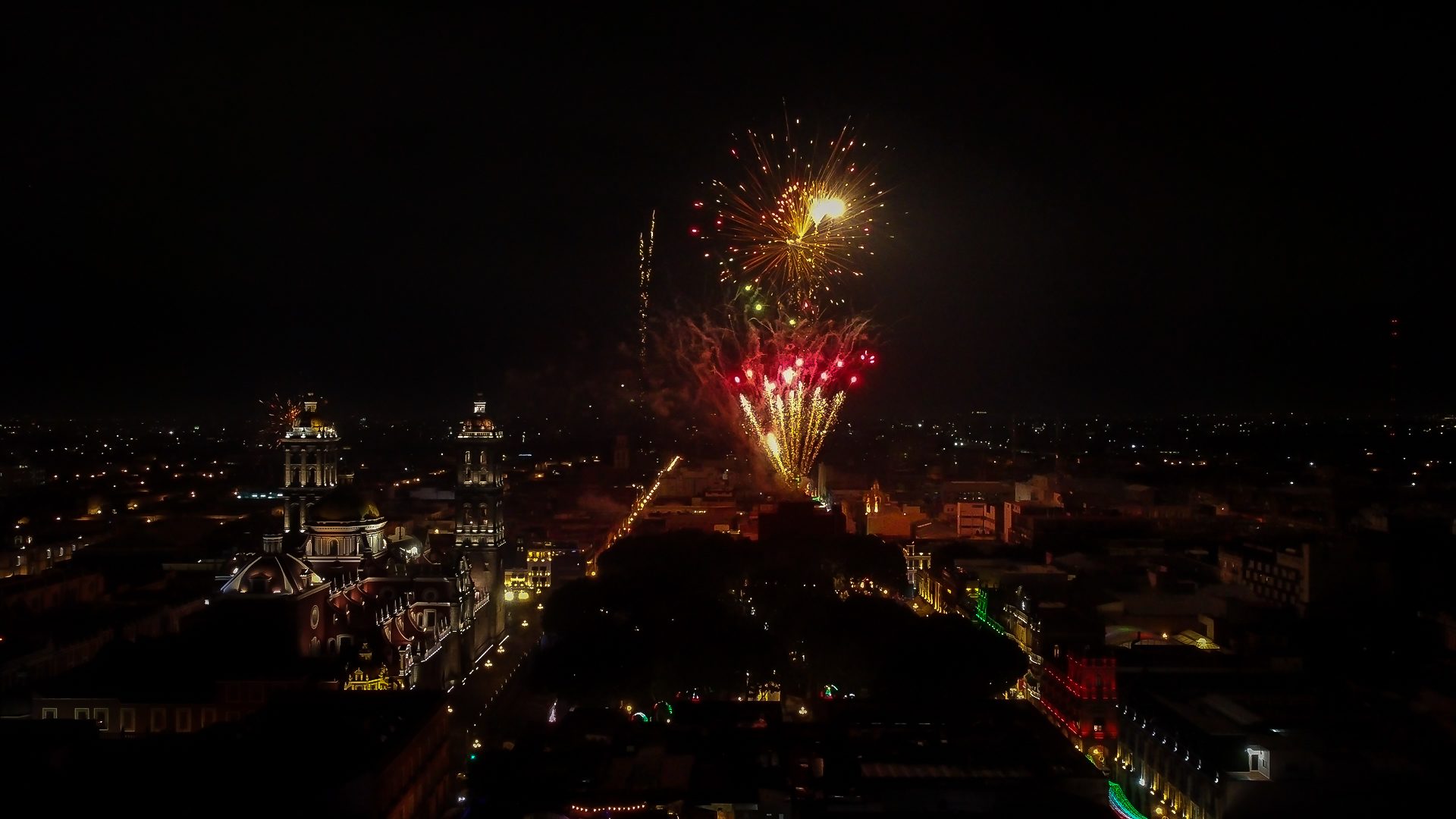 Vista aérea de evento masivo nocturno con pirotecnia